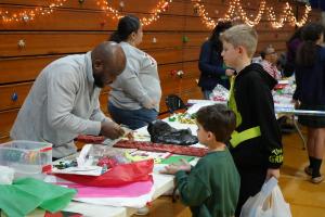 Photo of parents volunteering at an event and interacting with children